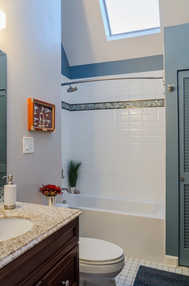This is an example of a medium sized contemporary bathroom in Chicago with recessed-panel cabinets, dark wood cabinets, an alcove bath, an alcove shower, a one-piece toilet, white tiles, metro tiles, blue walls, a submerged sink and engineered stone worktops.
