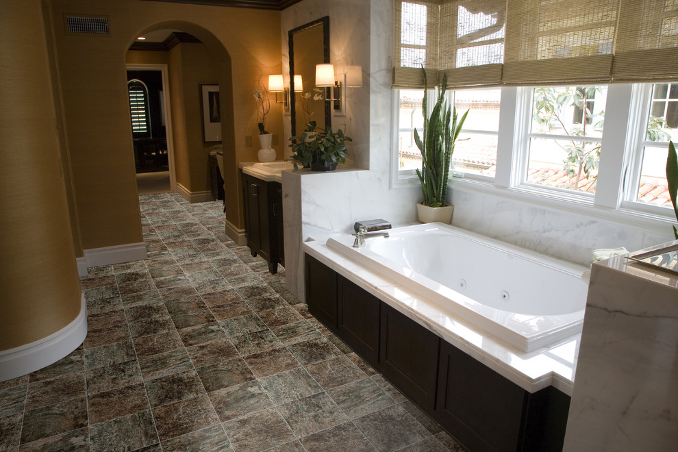 Foto di una stanza da bagno padronale minimal con ante in legno bruno, vasca da incasso, pareti beige, pavimento in vinile e top in marmo