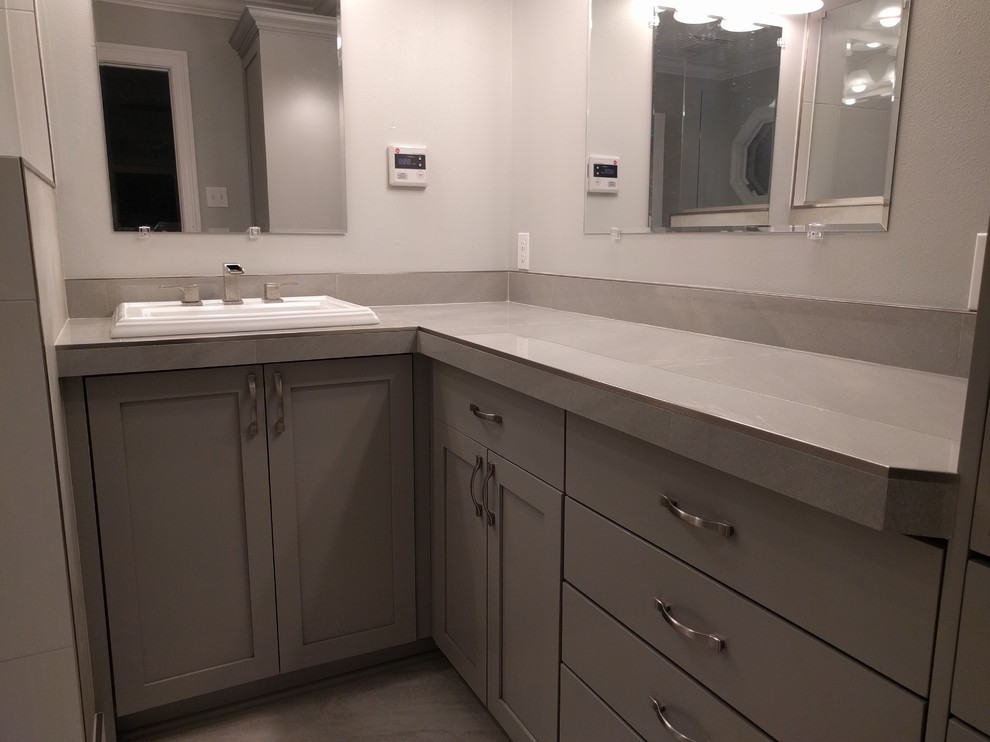 Inspiration for a medium sized contemporary ensuite bathroom in New Orleans with shaker cabinets, grey cabinets, a walk-in shower, a two-piece toilet, grey tiles, porcelain tiles, grey walls, porcelain flooring, a built-in sink and tiled worktops.