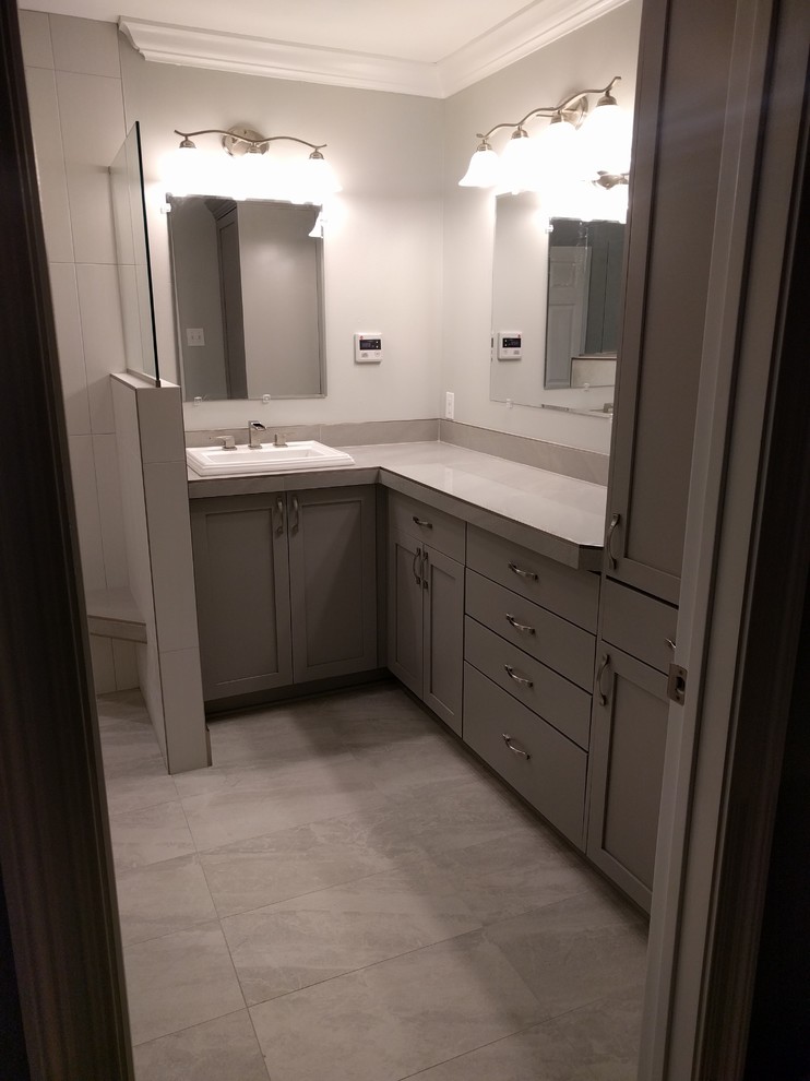 Modern inredning av ett mellanstort en-suite badrum, med skåp i shakerstil, grå skåp, en öppen dusch, en toalettstol med separat cisternkåpa, grå kakel, porslinskakel, grå väggar, klinkergolv i porslin, ett nedsänkt handfat och kaklad bänkskiva