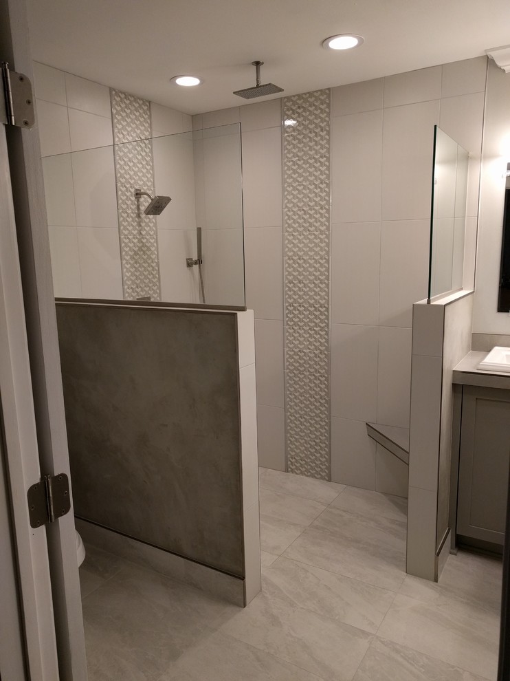 Doorless shower - mid-sized contemporary master gray tile and porcelain tile porcelain tile doorless shower idea in New Orleans with shaker cabinets, gray cabinets, a two-piece toilet, gray walls, a drop-in sink and tile countertops