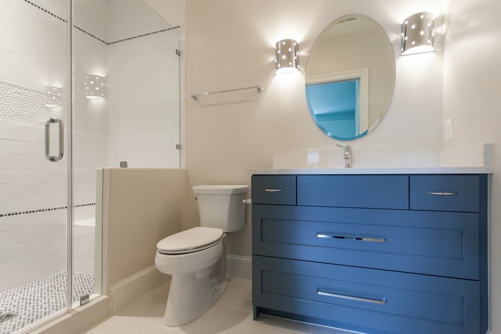 Cette photo montre une salle d'eau tendance de taille moyenne avec un placard à porte shaker, des portes de placard bleues, une baignoire indépendante, une douche ouverte, WC à poser, un mur blanc, un sol en linoléum, un lavabo encastré, un plan de toilette en granite, un sol blanc, une cabine de douche à porte coulissante et un plan de toilette blanc.
