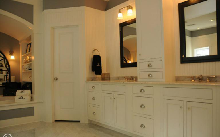 Bild på ett lantligt badrum, med ett undermonterad handfat, skåp i shakerstil, vita skåp, marmorbänkskiva, ett platsbyggt badkar, en hörndusch, en toalettstol med hel cisternkåpa, vit kakel och stenkakel