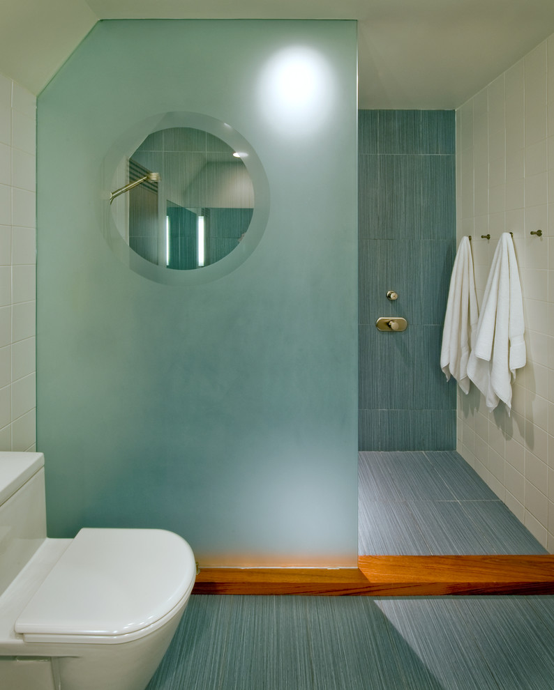 Свежая идея для дизайна: детская ванная комната среднего размера в современном стиле с монолитной раковиной, плоскими фасадами, фасадами цвета дерева среднего тона, столешницей из искусственного камня, угловым душем, унитазом-моноблоком, синей плиткой, керамогранитной плиткой, белыми стенами и полом из керамогранита - отличное фото интерьера