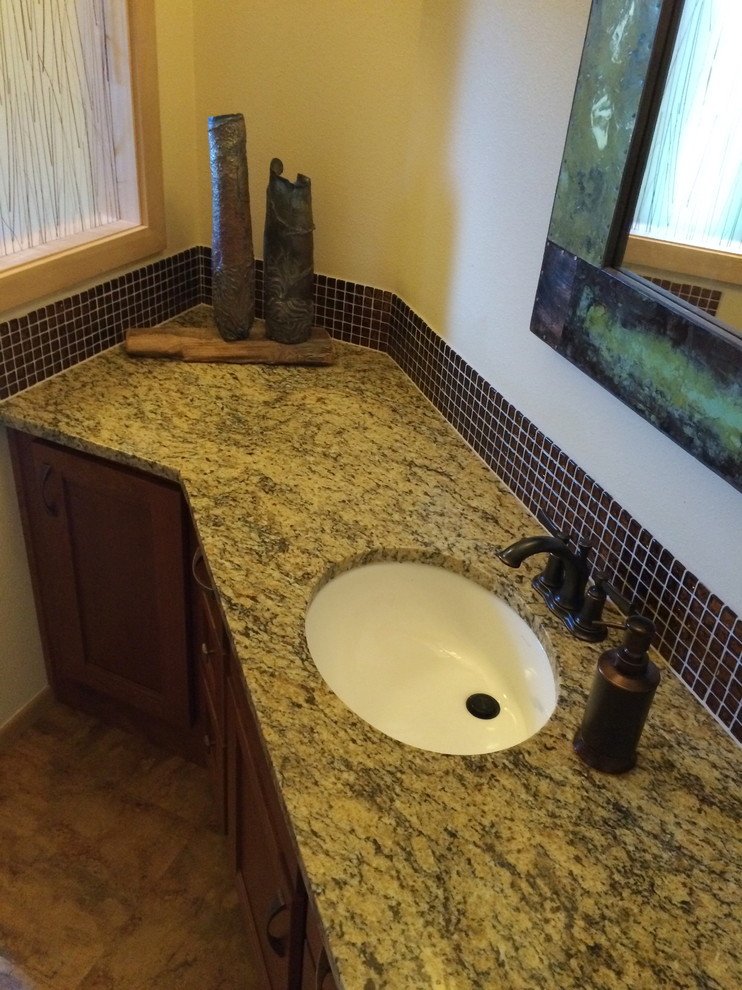 Idées déco pour une grande salle de bain classique en bois brun avec un placard à porte plane, un carrelage marron, un sol en linoléum, un lavabo encastré et un plan de toilette en granite.