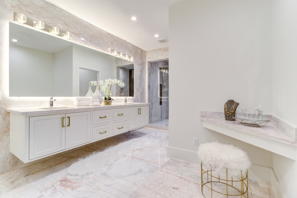 Large classic ensuite bathroom in Houston with recessed-panel cabinets, white cabinets, a one-piece toilet, white tiles, porcelain tiles, porcelain flooring, a submerged sink, marble worktops, beige floors, a hinged door, grey worktops, double sinks and a floating vanity unit.