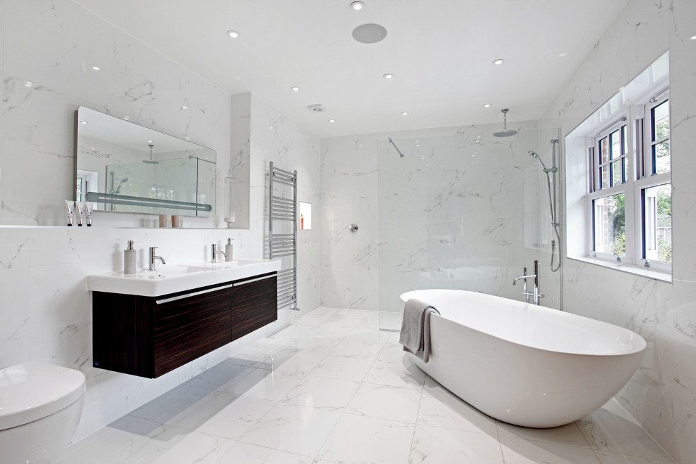 Cette image montre une salle de bain principale design en bois foncé avec un lavabo suspendu, un placard à porte plane, une baignoire indépendante, une douche ouverte et aucune cabine.