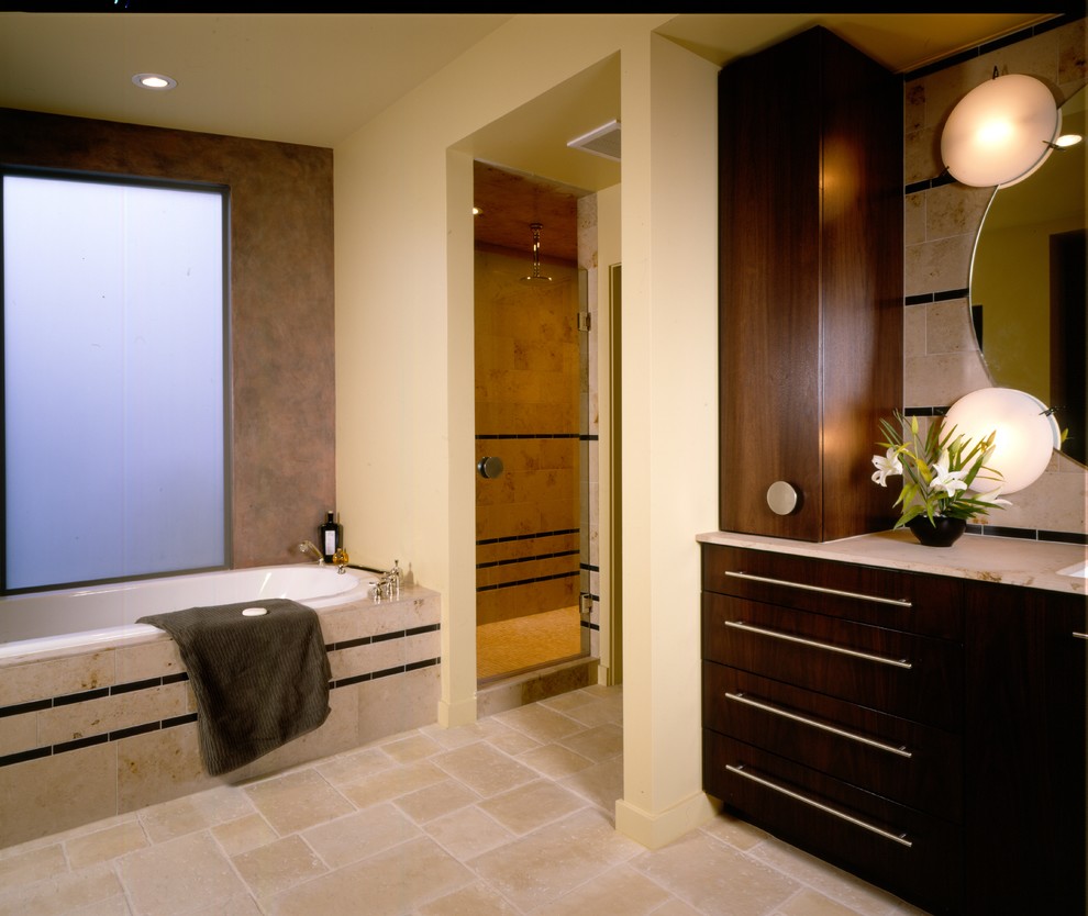 Imagen de cuarto de baño actual con lavabo bajoencimera, armarios con paneles lisos, puertas de armario de madera en tonos medios, encimera de granito, bañera encastrada, ducha empotrada, baldosas y/o azulejos beige y baldosas y/o azulejos de porcelana
