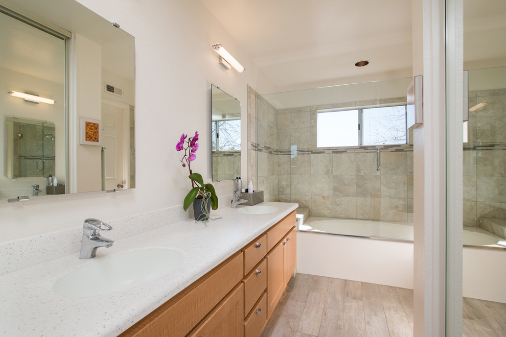 Inspiration for a medium sized traditional ensuite bathroom in San Diego with a built-in sink, recessed-panel cabinets, light wood cabinets, engineered stone worktops, a built-in bath, a two-piece toilet, grey tiles, porcelain tiles, white walls and porcelain flooring.