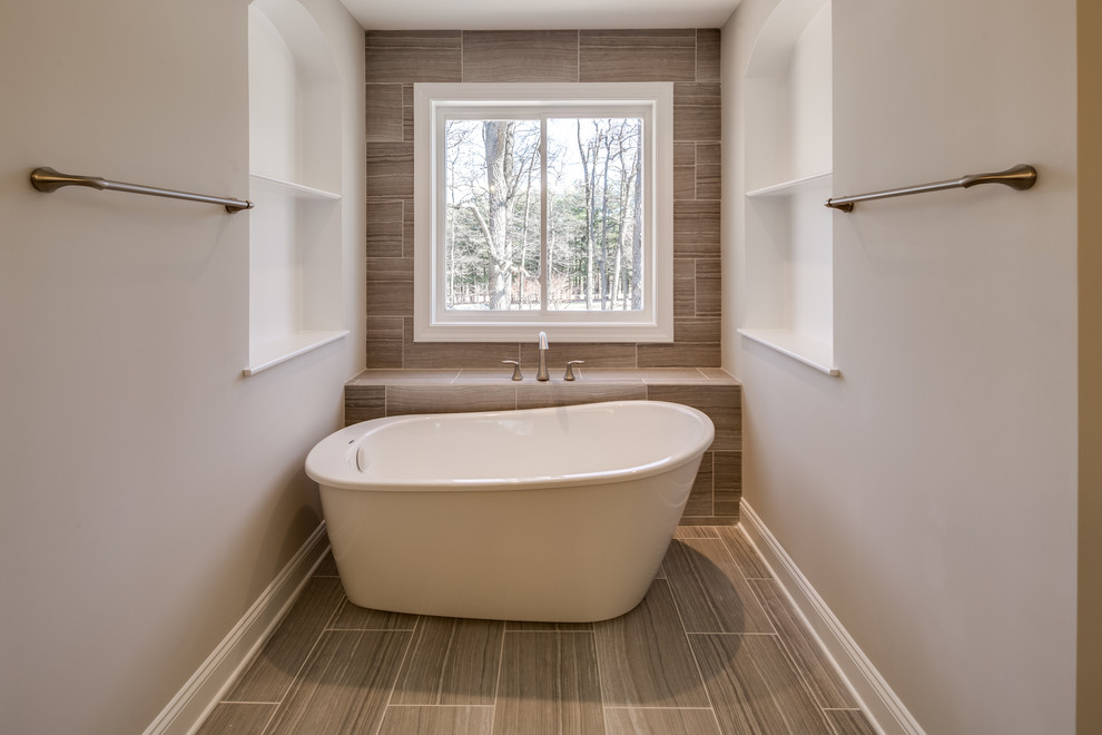 Large traditional ensuite bathroom in Baltimore with raised-panel cabinets, dark wood cabinets, a freestanding bath, an alcove shower, a two-piece toilet, beige tiles, brown tiles, stone slabs, grey walls, slate flooring, a submerged sink, granite worktops, grey floors and a hinged door.