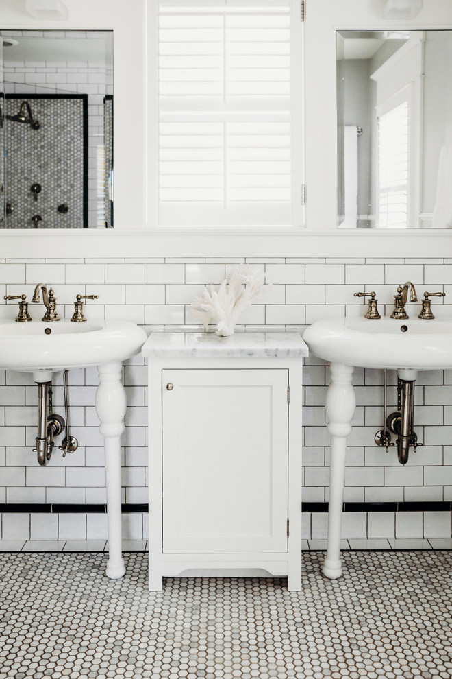 Example of a mid-sized transitional master white tile and subway tile marble floor and multicolored floor alcove shower design in Portland with recessed-panel cabinets, white cabinets, a one-piece toilet, white walls, a pedestal sink, marble countertops and a hinged shower door