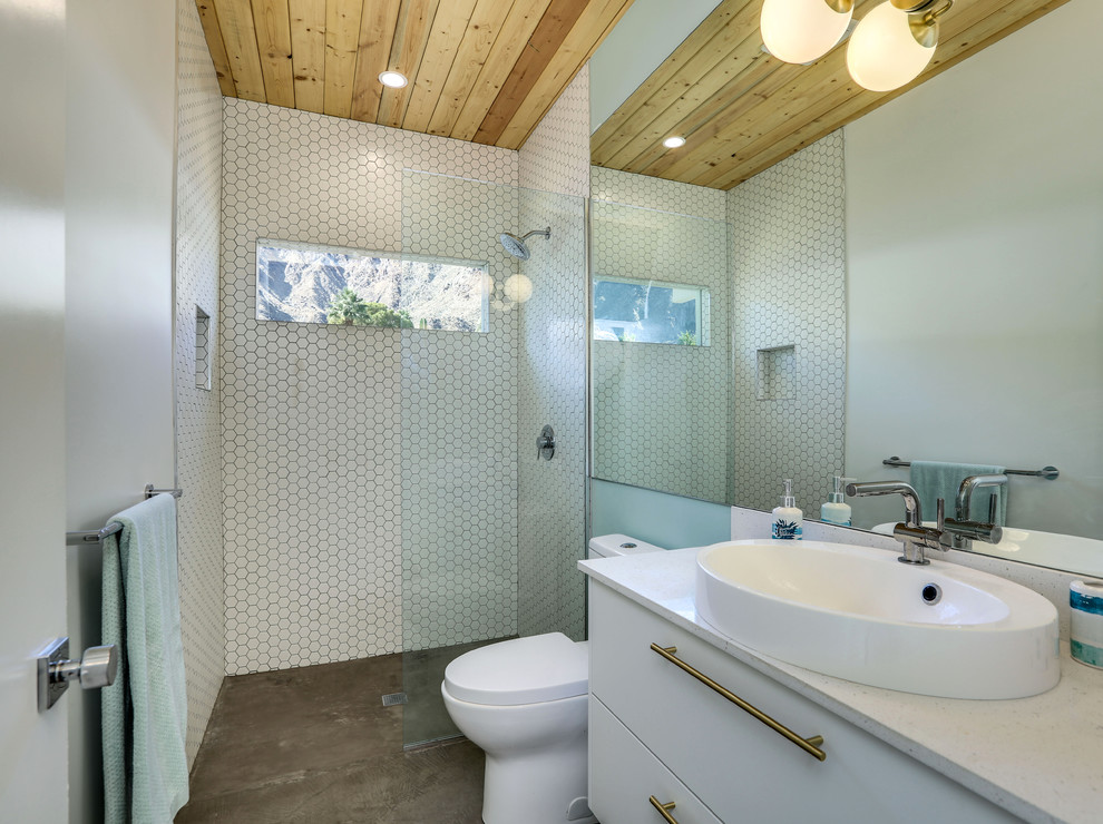 Photo of a midcentury bathroom in Other with flat-panel cabinets, white cabinets, a built-in shower, white tiles, mosaic tiles, white walls, concrete flooring, a vessel sink, grey floors, an open shower and white worktops.