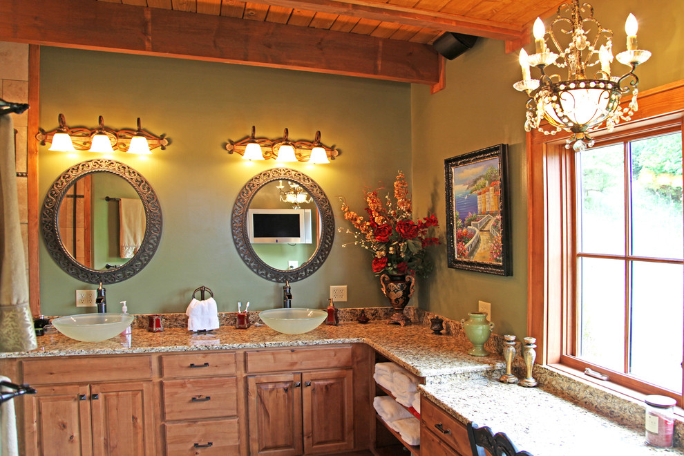 シャーロットにある高級な広いラスティックスタイルのおしゃれなマスターバスルーム (ベッセル式洗面器、レイズドパネル扉のキャビネット、淡色木目調キャビネット、御影石の洗面台、緑の壁、無垢フローリング) の写真