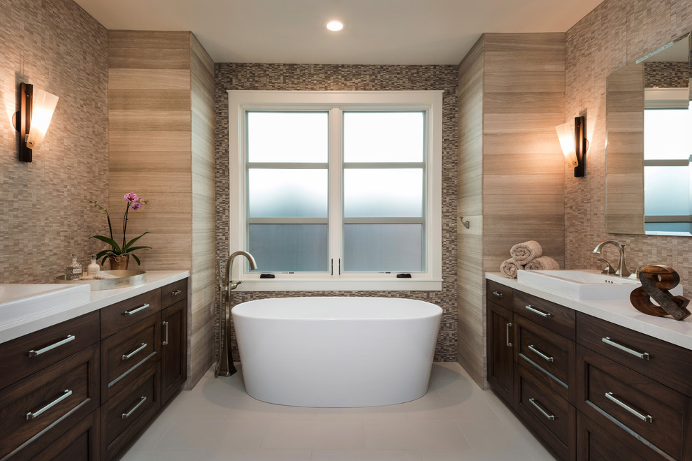 Design ideas for a large classic ensuite bathroom in San Diego with recessed-panel cabinets, dark wood cabinets, a freestanding bath, a corner shower, a one-piece toilet, beige tiles, porcelain tiles, beige walls, porcelain flooring, a vessel sink, engineered stone worktops, beige floors and a hinged door.