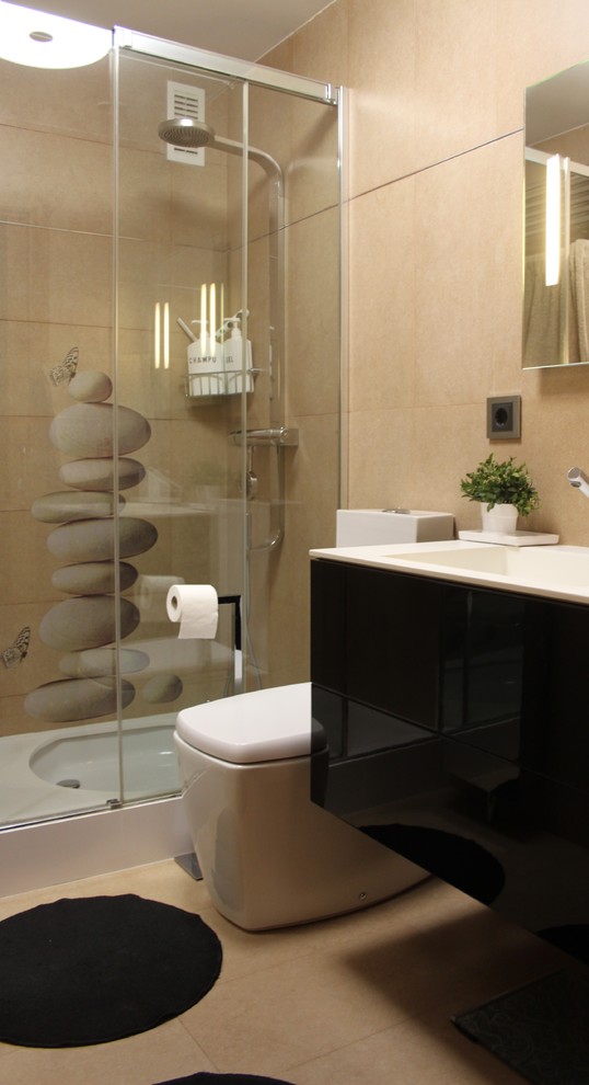 Réalisation d'une salle de bain design de taille moyenne avec un placard à porte plane, des portes de placard noires, WC séparés, un mur beige, un sol en carrelage de céramique et un lavabo intégré.