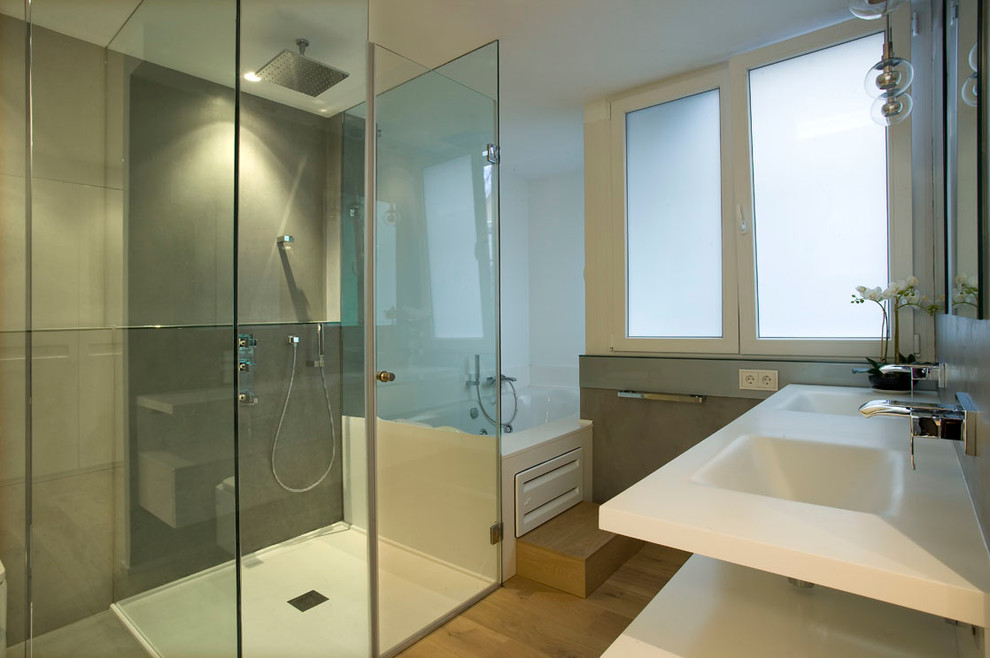 Foto på ett mellanstort funkis badrum med dusch, med en jacuzzi, en kantlös dusch, grå väggar, mellanmörkt trägolv och ett integrerad handfat