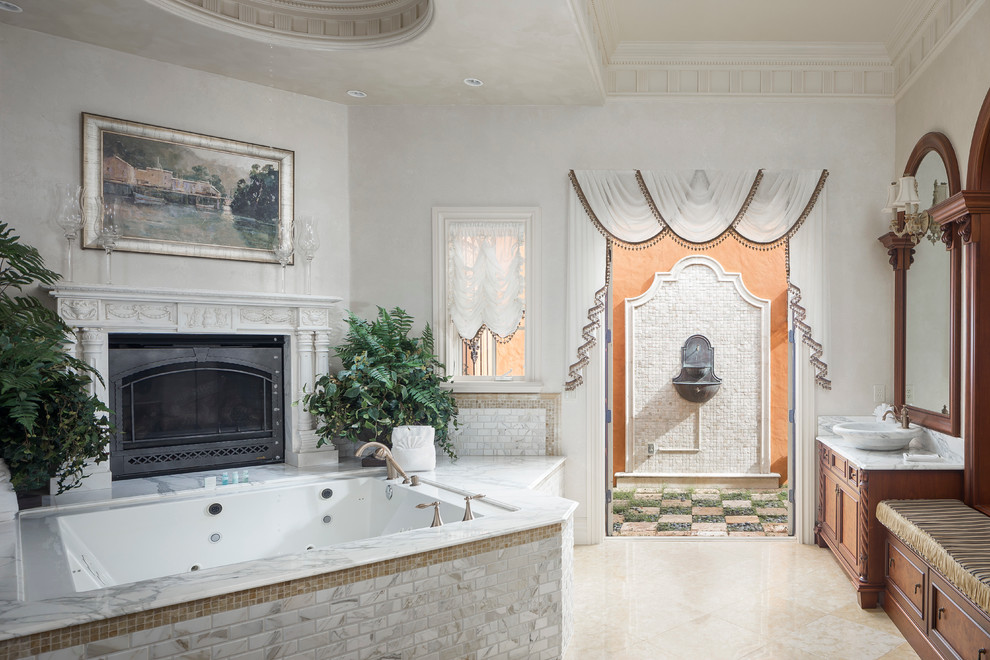 Ispirazione per una stanza da bagno mediterranea con ante in legno bruno, vasca sottopiano, piastrelle bianche, pareti bianche e lavabo a bacinella