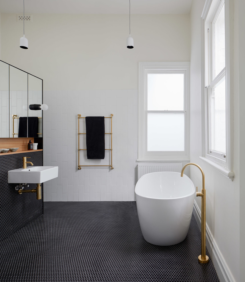 メルボルンにあるお手頃価格の小さなコンテンポラリースタイルのおしゃれな浴室 (置き型浴槽、白いタイル、白い壁、モザイクタイル、黒い床) の写真