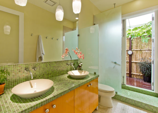 Inspiration för ett mellanstort funkis en-suite badrum, med ett fristående handfat, släta luckor, skåp i mellenmörkt trä, en öppen dusch, en toalettstol med separat cisternkåpa, grön kakel, glaskakel, gula väggar, travertin golv och kaklad bänkskiva