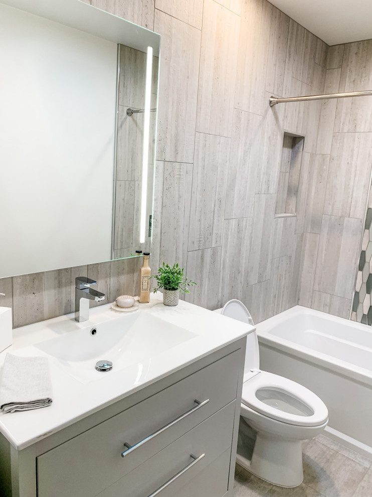 Photo of a small contemporary bathroom in San Francisco with flat-panel cabinets, grey cabinets, an alcove bath, a shower/bath combination, a one-piece toilet, grey tiles, porcelain tiles, grey walls, porcelain flooring, an integrated sink, solid surface worktops, grey floors, a shower curtain, white worktops, a wall niche, a single sink and a freestanding vanity unit.