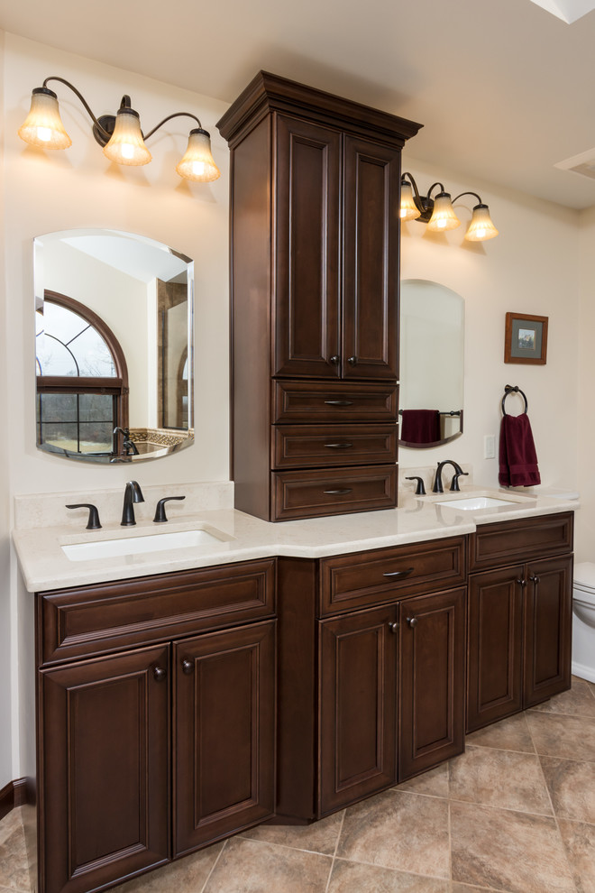 Bathroom - large traditional master beige tile and stone tile brown floor bathroom idea in Detroit with flat-panel cabinets, dark wood cabinets, a two-piece toilet, beige walls, an undermount sink, quartz countertops and a hinged shower door