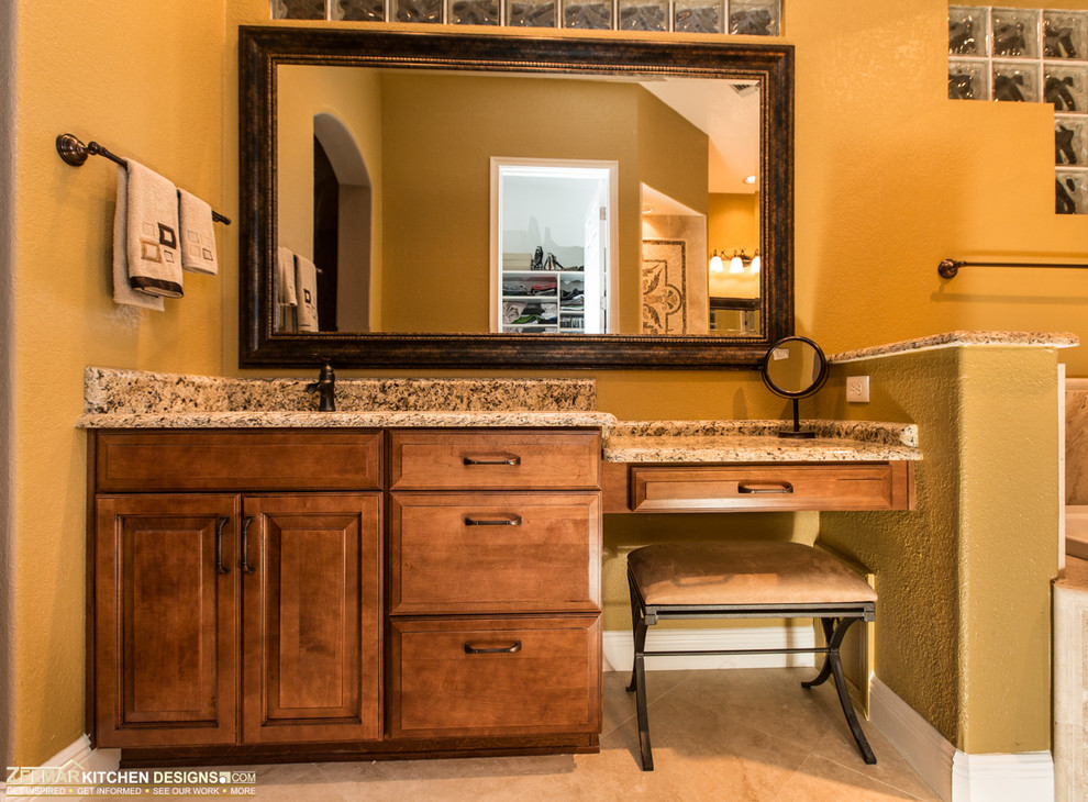 Aménagement d'une grande salle de bain principale classique en bois brun avec un lavabo encastré, un placard avec porte à panneau surélevé, un plan de toilette en granite, une baignoire posée, une douche d'angle, un carrelage beige, un carrelage de pierre, un mur jaune et un sol en travertin.