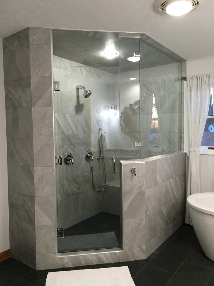 This is an example of a large traditional ensuite bathroom in Other with raised-panel cabinets, medium wood cabinets, a freestanding bath, a corner shower, a two-piece toilet, grey tiles, porcelain tiles, grey walls, porcelain flooring, a submerged sink and granite worktops.