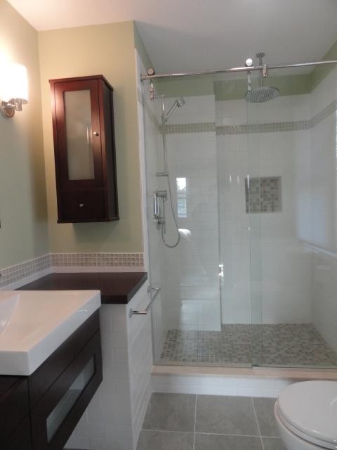 Idee per una stanza da bagno minimal con lavabo a bacinella, ante in legno bruno, top in legno, doccia alcova, WC monopezzo e piastrelle in gres porcellanato