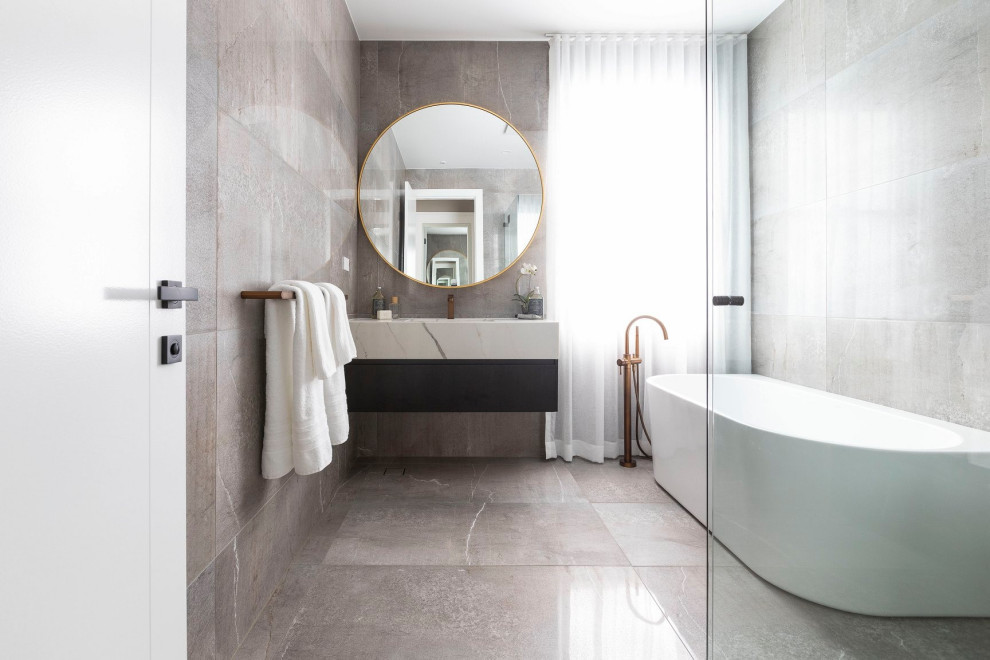 Bild på ett funkis flerfärgad flerfärgat en-suite badrum, med släta luckor, ett fristående badkar, en kantlös dusch, ett integrerad handfat, marmorbänkskiva, flerfärgat golv och dusch med gångjärnsdörr