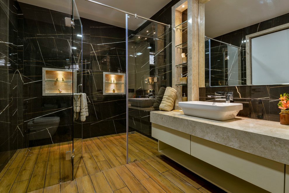 Идея дизайна: ванная комната среднего размера в современном стиле с плоскими фасадами, бежевыми фасадами, душем без бортиков, черной плиткой, черными стенами, настольной раковиной, коричневым полом, душем с распашными дверями и серой столешницей