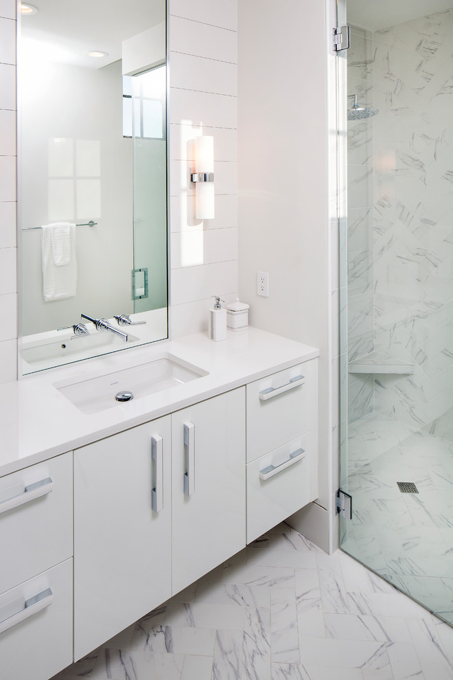Walk-in shower - mid-sized contemporary kids' multicolored tile and porcelain tile medium tone wood floor and multicolored floor walk-in shower idea in Charleston with flat-panel cabinets, white cabinets, a one-piece toilet, multicolored walls, an undermount sink, quartz countertops and a hinged shower door