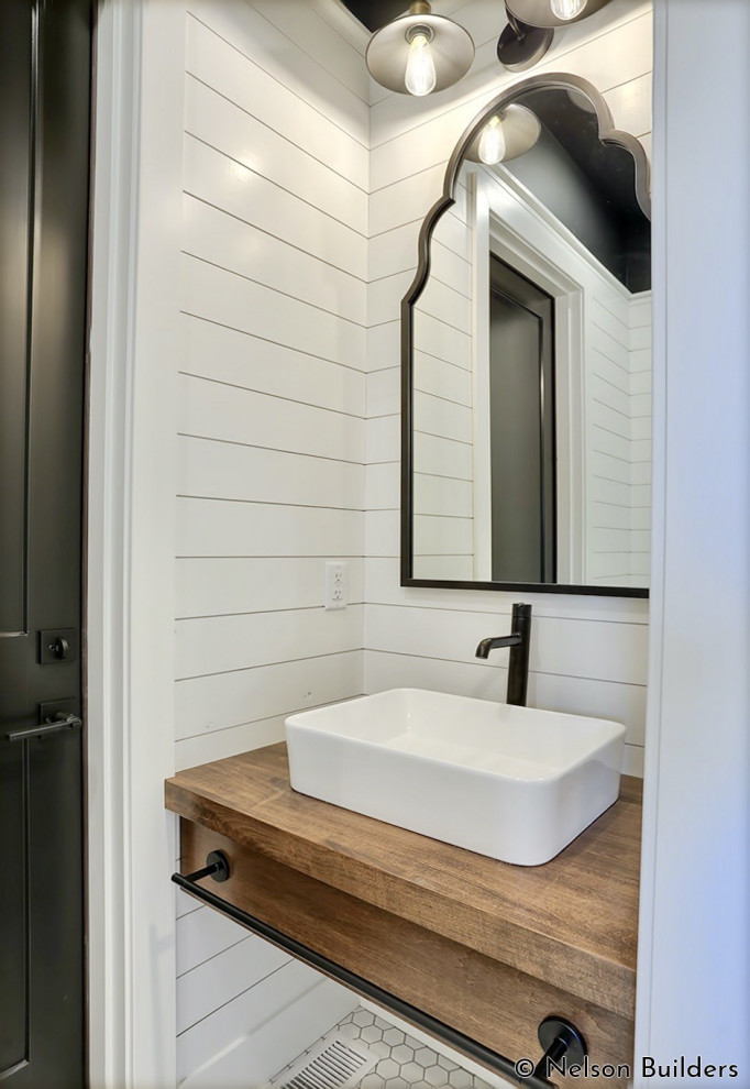 Inredning av ett lantligt litet brun brunt badrum med dusch, med öppna hyllor, skåp i mellenmörkt trä, vita väggar, mosaikgolv, ett fristående handfat, träbänkskiva och vitt golv