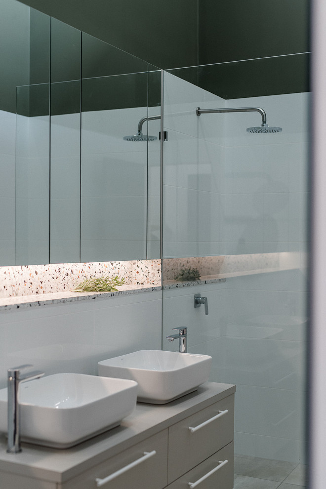 Inspiration för små moderna grått en-suite badrum, med grå skåp, en vägghängd toalettstol, vit kakel, stenkakel, vita väggar, klinkergolv i porslin, ett fristående handfat, laminatbänkskiva, beiget golv, med dusch som är öppen, släta luckor och en dusch i en alkov