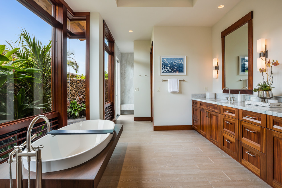 Inspiration for a tropical porcelain tile and beige floor freestanding bathtub remodel in Hawaii with shaker cabinets, medium tone wood cabinets, beige walls, an undermount sink and quartzite countertops