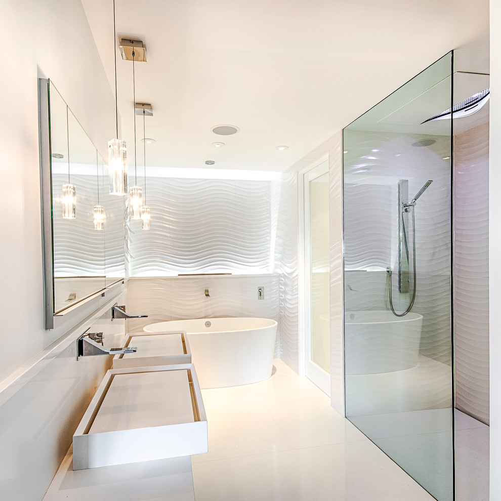 Modelo de cuarto de baño actual con lavabo sobreencimera, ducha a ras de suelo y bañera exenta