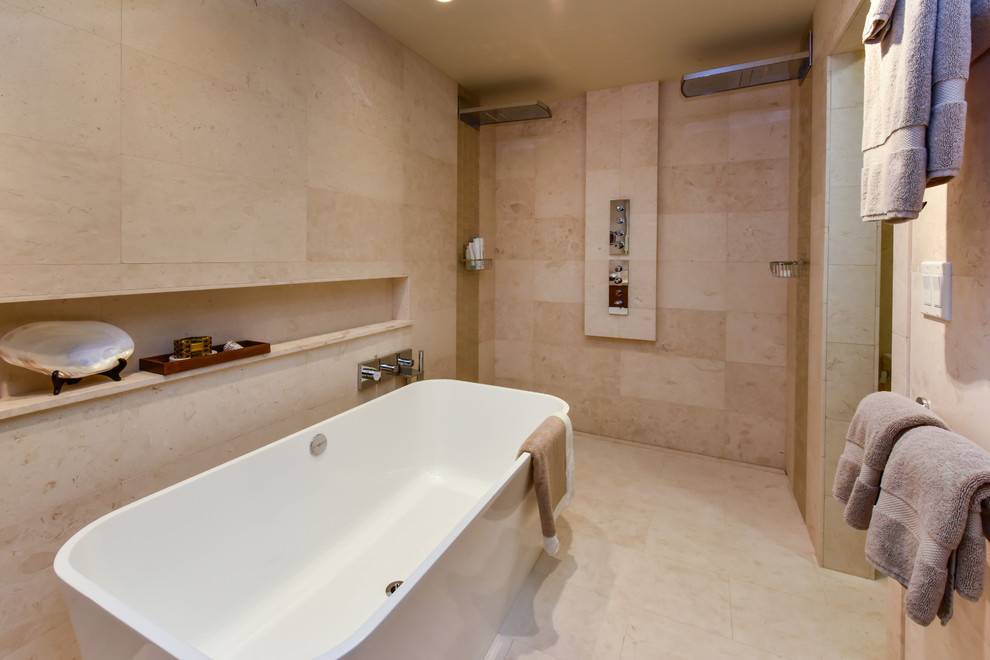 Inspiration pour une salle de bain principale design en bois brun de taille moyenne avec un placard à porte plane, une baignoire indépendante, une douche double, WC à poser, un carrelage beige, du carrelage en pierre calcaire, un mur beige, un sol en calcaire, un lavabo encastré, un sol beige et aucune cabine.