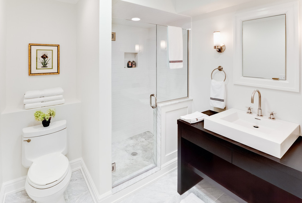 ニューヨークにある広いトラディショナルスタイルのおしゃれなマスターバスルーム (ベッセル式洗面器、オープンシェルフ、濃色木目調キャビネット、アルコーブ型シャワー、白いタイル、サブウェイタイル、白い壁、一体型トイレ	、大理石の床、木製洗面台) の写真