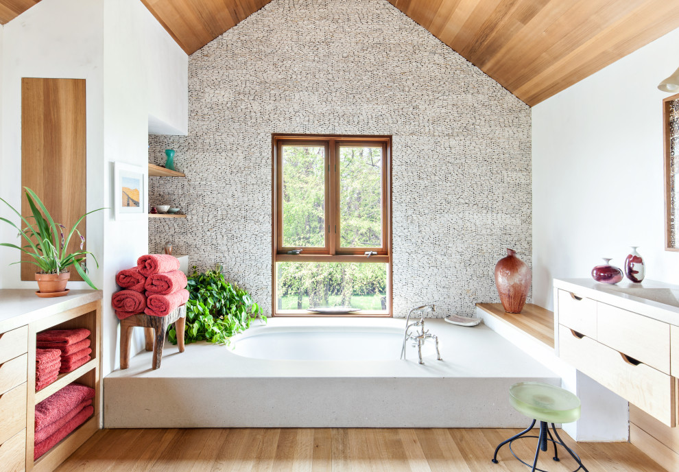 Inspiration för stora moderna vitt en-suite badrum, med släta luckor, skåp i ljust trä, ett undermonterat badkar, vit kakel, ljust trägolv, ett integrerad handfat och beiget golv
