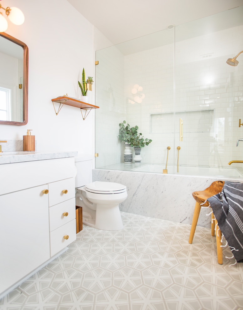 Idéer för ett modernt badrum, med släta luckor, vita skåp, ett undermonterat badkar, vit kakel, tunnelbanekakel, vita väggar, cementgolv och grått golv