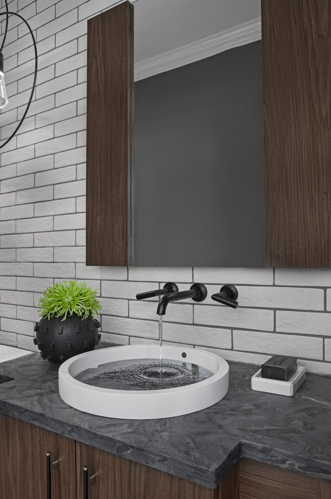 Exemple d'une petite salle de bain tendance en bois foncé avec un placard à porte plane, WC à poser, un carrelage noir et blanc, des carreaux de porcelaine, un mur blanc, un sol en bois brun, une vasque, un plan de toilette en granite, un sol marron et un plan de toilette noir.