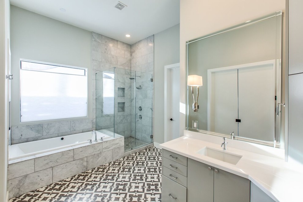 Exemple d'une grande salle de bain principale moderne avec un placard à porte plane, une baignoire posée, une douche d'angle, un carrelage gris, un carrelage blanc, un lavabo encastré, des portes de placard grises, WC séparés, du carrelage en marbre, un mur gris, carreaux de ciment au sol, un plan de toilette en quartz modifié, un sol multicolore et une cabine de douche à porte battante.
