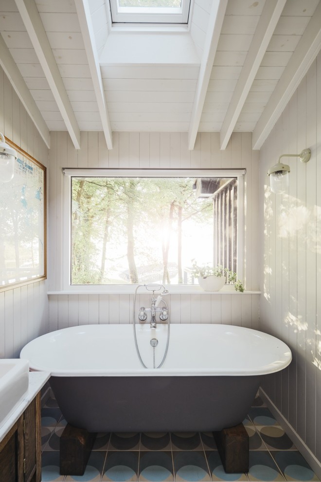 Inspiration för små rustika badrum, med cementgolv, flerfärgat golv och ett fristående badkar