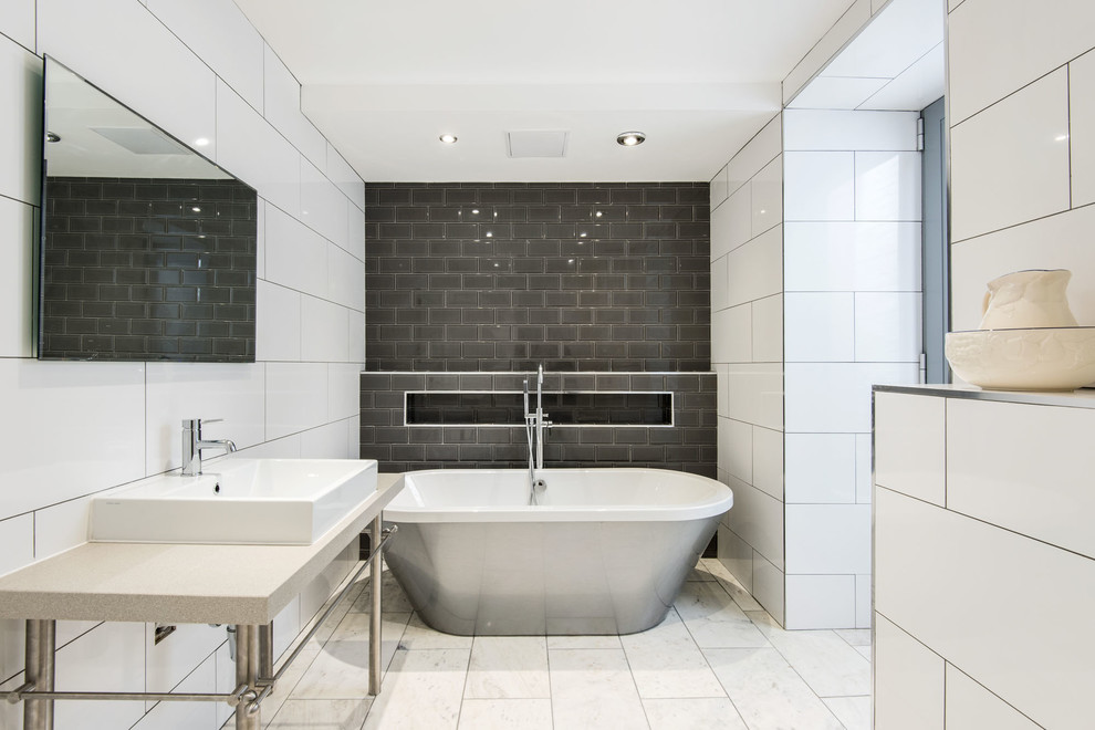 Modelo de cuarto de baño gris y blanco actual con bañera exenta, baldosas y/o azulejos grises, baldosas y/o azulejos blancos y baldosas y/o azulejos de cemento