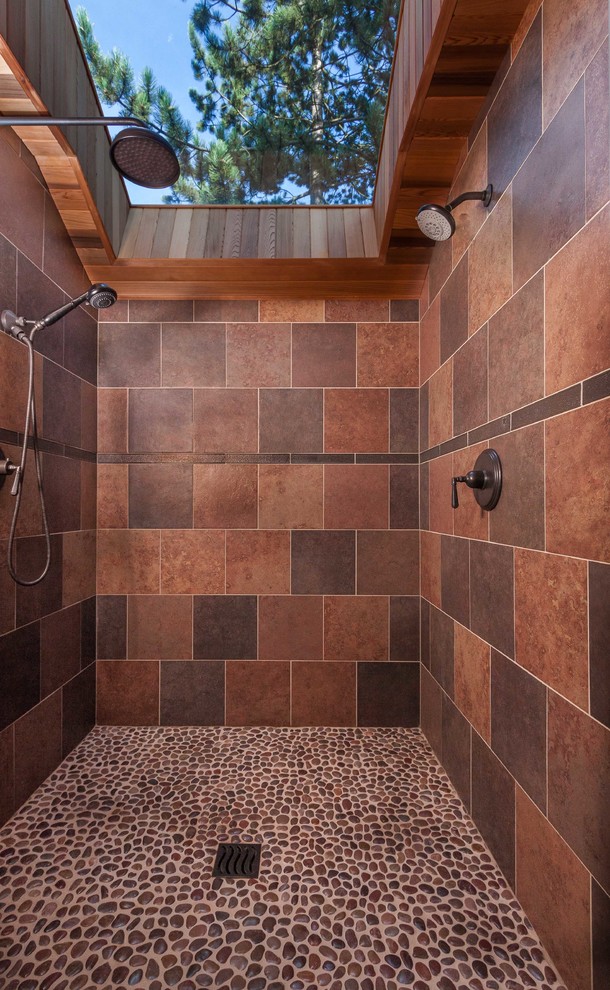 Aménagement d'une douche en alcôve classique avec un carrelage beige, un carrelage marron, un sol en galet, aucune cabine et un sol marron.