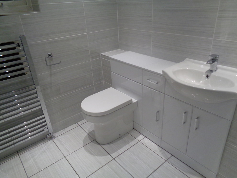Ispirazione per una stanza da bagno con doccia minimalista di medie dimensioni con piastrelle grigie, piastrelle in ceramica, pareti grigie, pavimento con piastrelle in ceramica e pavimento grigio