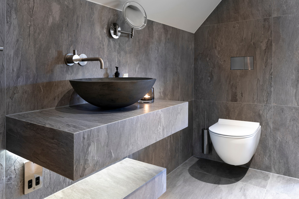 Inspiration för små moderna grått badrum med dusch, med öppna hyllor, våtrum, en vägghängd toalettstol, grå kakel, porslinskakel, grå väggar, klinkergolv i porslin, ett avlångt handfat, kaklad bänkskiva, grått golv och med dusch som är öppen