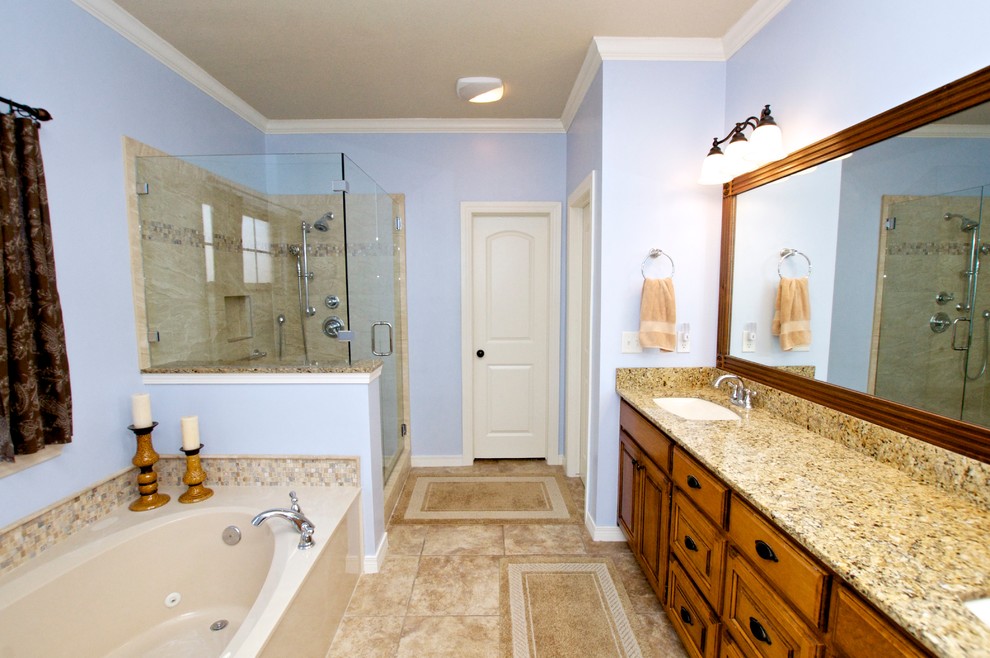 Пример оригинального дизайна: большая главная ванная комната в стиле фьюжн с фасадами с выступающей филенкой, фасадами цвета дерева среднего тона, ванной в нише, угловым душем, унитазом-моноблоком, бежевой плиткой, керамической плиткой, фиолетовыми стенами, врезной раковиной, полом из керамической плитки и столешницей из гранита