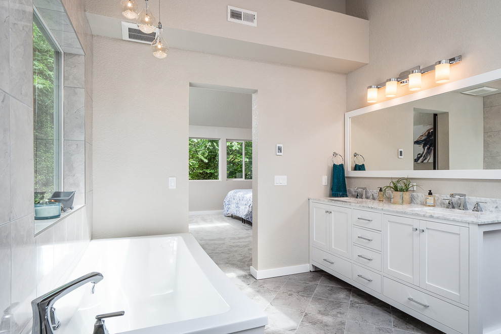 Idéer för att renovera ett stort funkis vit vitt en-suite badrum, med skåp i shakerstil, vita skåp, ett fristående badkar, en kantlös dusch, grå kakel, porslinskakel, klinkergolv i porslin, ett undermonterad handfat, marmorbänkskiva, grått golv och med dusch som är öppen
