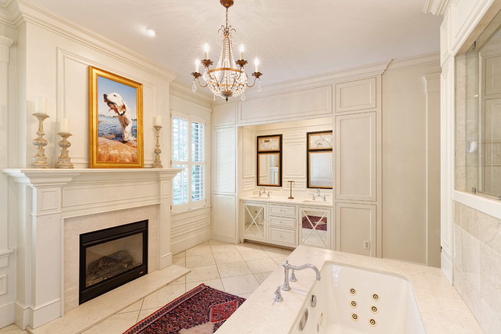Klassisk inredning av ett beige beige en-suite badrum, med ett undermonterat badkar, ett undermonterad handfat, beige skåp, beige kakel, beige väggar, beiget golv och luckor med profilerade fronter