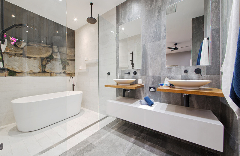 Стильный дизайн: главная ванная комната в современном стиле с плоскими фасадами, белыми фасадами, отдельно стоящей ванной, душевой комнатой, серой плиткой, плиткой из листового камня, настольной раковиной и столешницей из дерева - последний тренд